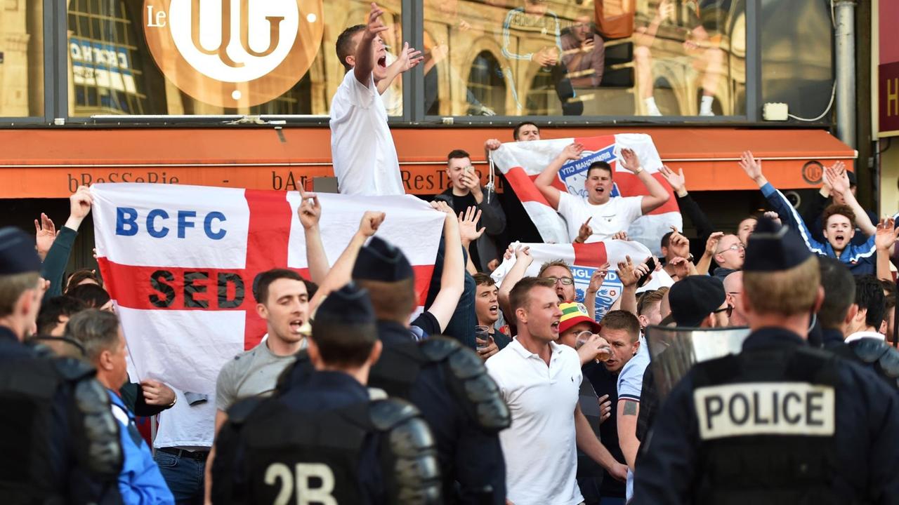Polizeibeamte überwachen englische Fans in der Innenstadt von Lille, die Flaggen schwenken Polizeibeamte überwachen englische Fans in der Innenstadt von Lille, die Flaggen schwenken