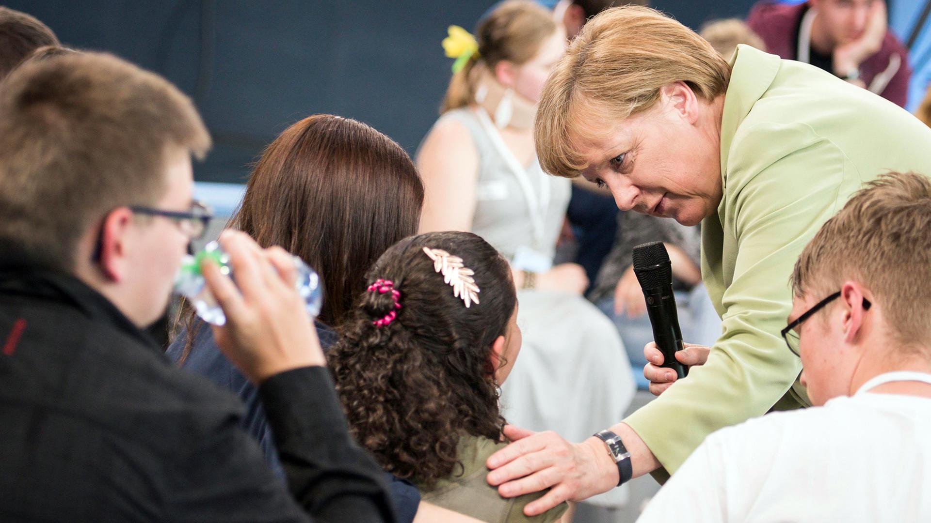 Bundeskanzlerin Angela Merkel (CDU) mit dem Flüchtlingsmädchen Reem Sawihl, das in einer öffentlichen Diskussion mit Merkel in Rostock in Tränen ausgebrochen war Bundeskanzlerin Angela Merkel (CDU) mit dem Flüchtlingsmädchen Reem Sawihl, das in einer öffentlichen Diskussion mit Merkel in Rostock in Tränen ausgebrochen war