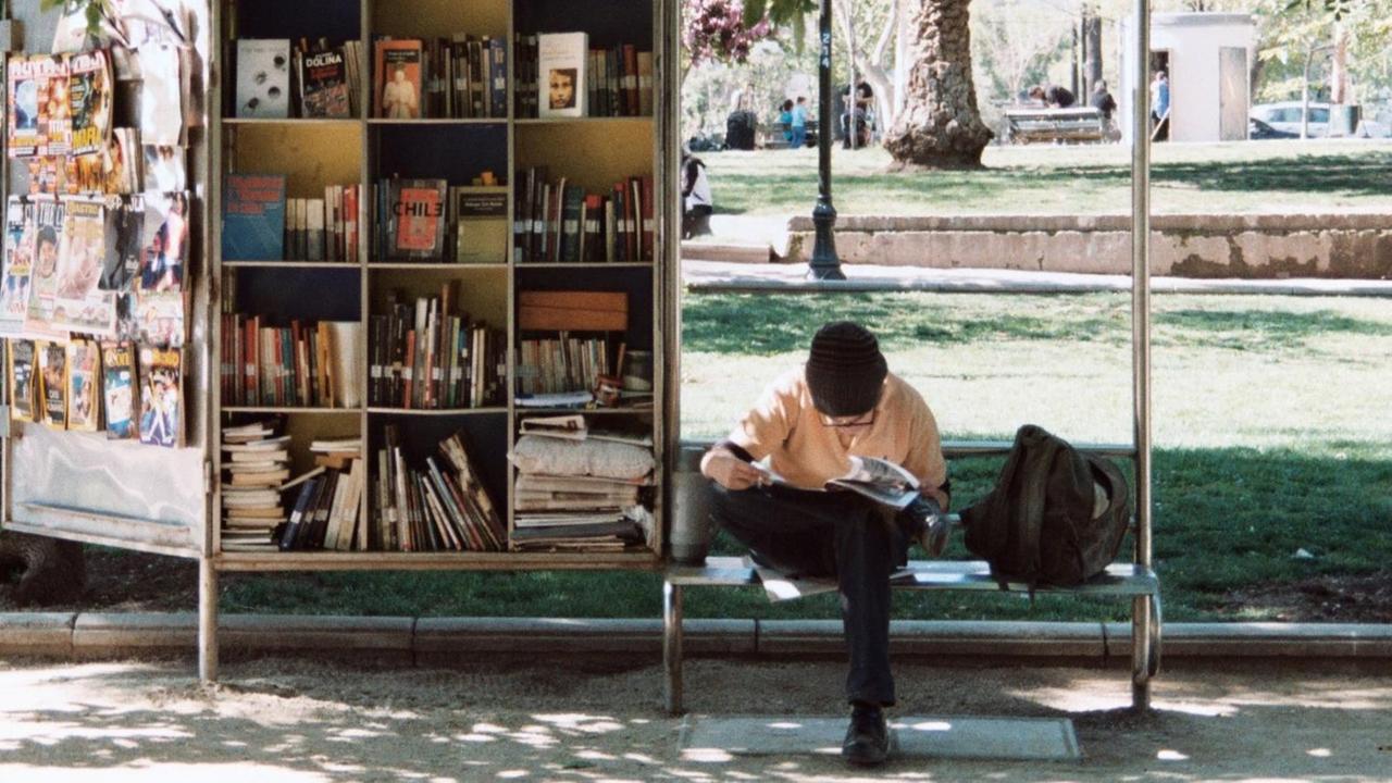 Ein Mann liest vor einem Bücherstand. Ein Mann liest vor einem Bücherstand.