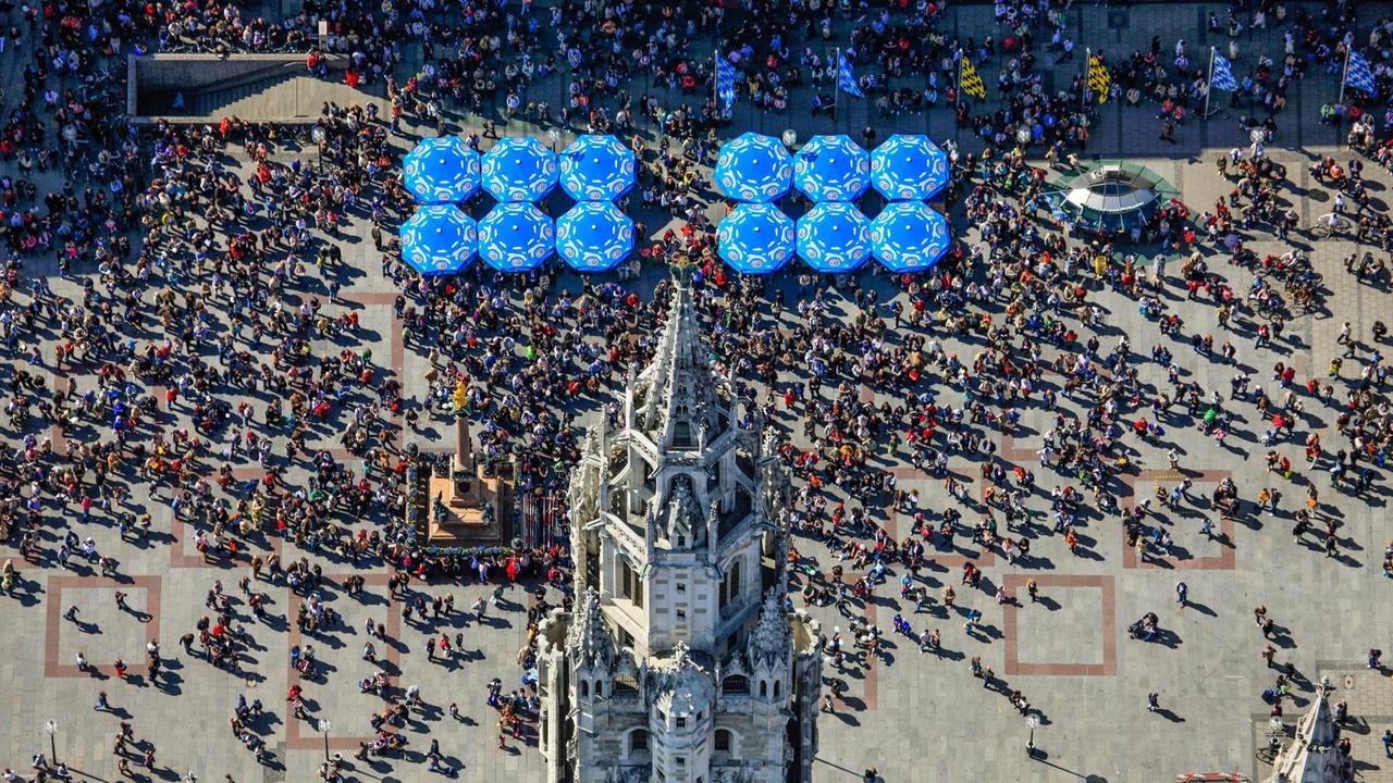 Luftbild vom Rathausturm am Marienplatz in München, vor dem die Touristen auf das Glockenspiel warten Luftbild vom Rathausturm am Marienplatz in München, vor dem die Touristen auf das Glockenspiel warten
