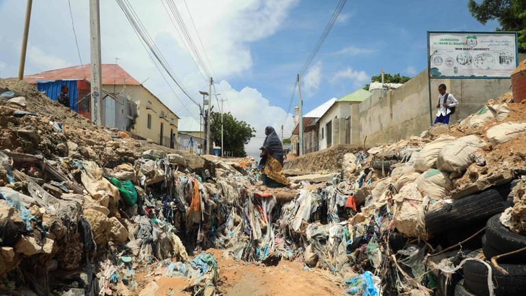 Eine Frau geht über eine zerstörte Straße in Somalias Hauptstadt Mogadischu