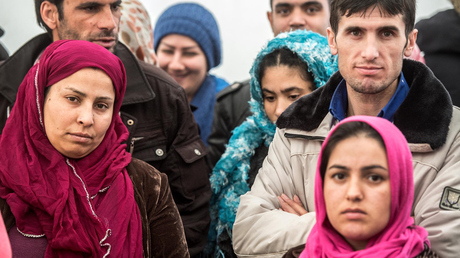 Frauen und Männer aus Afghanistan und Pakistan warten in einer Flüchtlingsunterkunft in Limburg an der Lahn auf den Beginn der Essensausgabe.