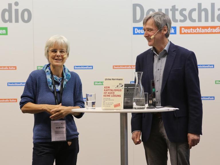 Sie sehen die Buchautorin Ulrike Herrmann und den Deutschlandfunk-Redakteur Georg Ehring.