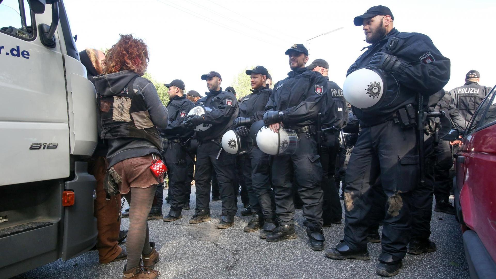Uniformierte Polizisten stehen aufgereiht vor einem LKW, an dem ein Demonstrant lehnt Uniformierte Polizisten stehen aufgereiht vor einem LKW, an dem ein Demonstrant lehnt