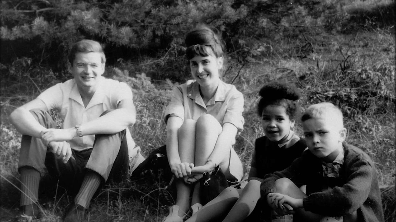 Ines Johnson-Spain sitzt als Kind mit ihrer Familie auf einer Wiese. Ines Johnson-Spain sitzt als Kind mit ihrer Familie auf einer Wiese.