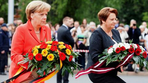 Bundeskanzlerin Angela Merkel und die lettische Ministerpräsidentin Laimdota Straujuma legen am Freiheitsdenkmal in Riga Kränze nieder.
