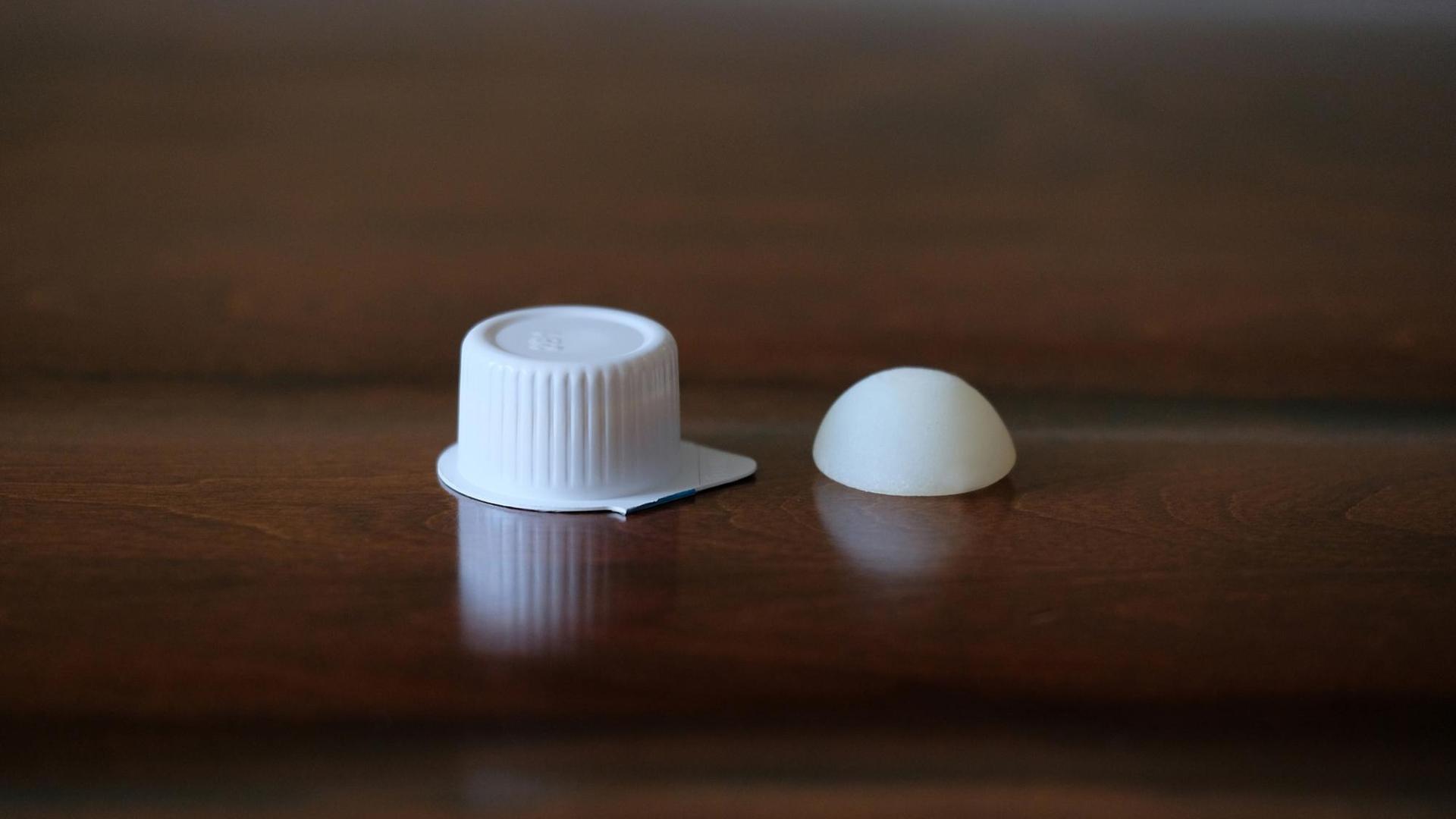 Das Foto zeigt links ein klassisches Milchdöschen in Plastikverpackung, recht daneben die auflösbare Milchkapsel Das Foto zeigt links ein klassisches Milchdöschen in Plastikverpackung, recht daneben die auflösbare Milchkapsel
