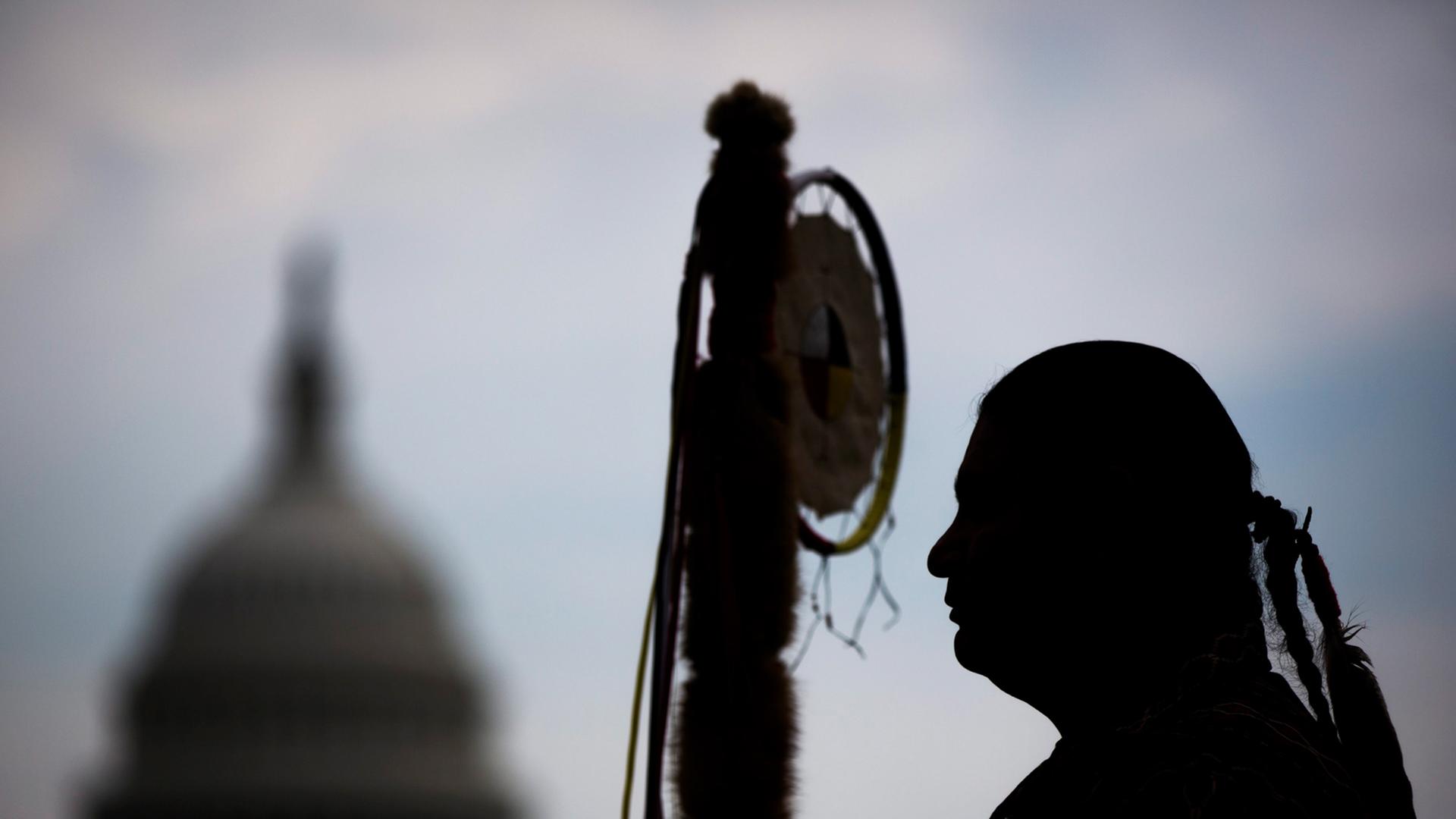 Matthew Black Eagle Man, Mitglied der Dakota Sioux Nation, wartet in Washington, DC, auf die Stammesführer der Cowboy and Indian Alliance, um gemeinsam mit einem Ritt zu Pferde gegen die Keystone XL Pipeline zu deomonstrieren. Im Hintergrund ist die Kuppel des Capitols zu sehen.