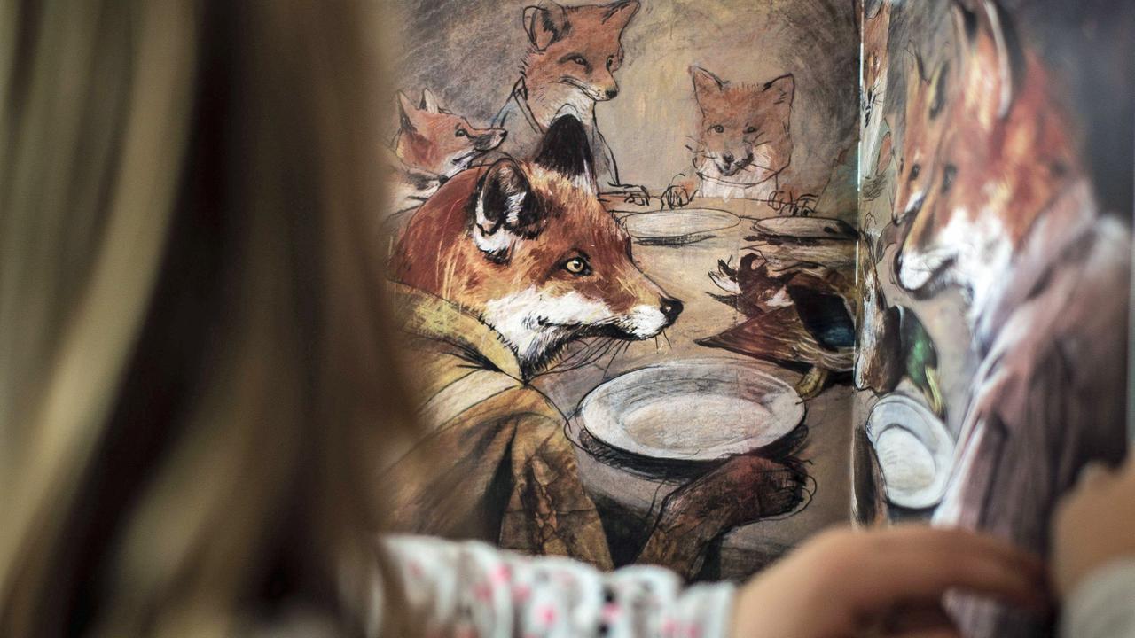 Ein Kind blättert in einem Bilderbuich mit Illustrationen von Jonas Lauströer. Ein Kind blättert in einem Bilderbuich mit Illustrationen von Jonas Lauströer.