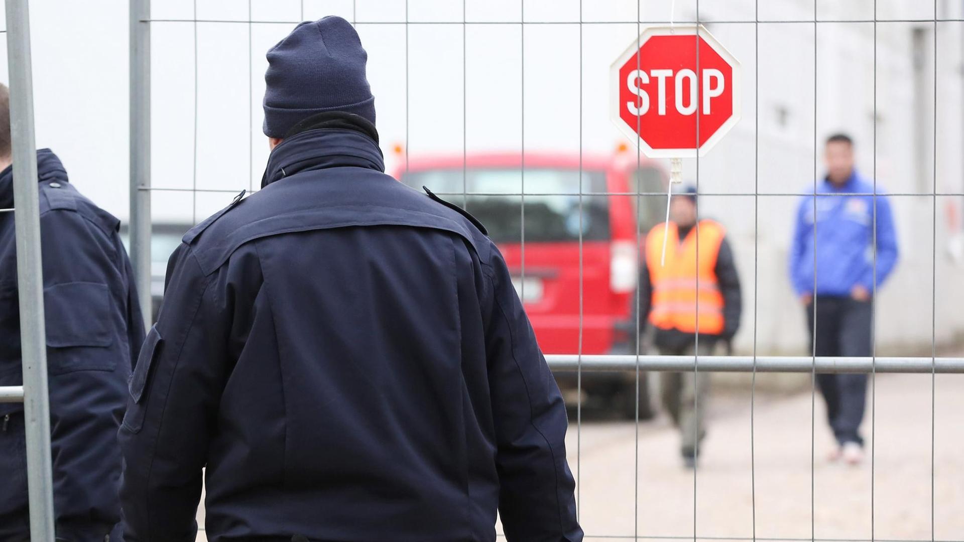 Mitarbeiter eines Sicherheitsdienstes gehen am 01.12.2014 auf das Gelände einer Flüchtlingsunterkunft in Hamburg-Bahrenfeld. Mitarbeiter eines Sicherheitsdienstes gehen am 01.12.2014 auf das Gelände einer Flüchtlingsunterkunft in Hamburg-Bahrenfeld.