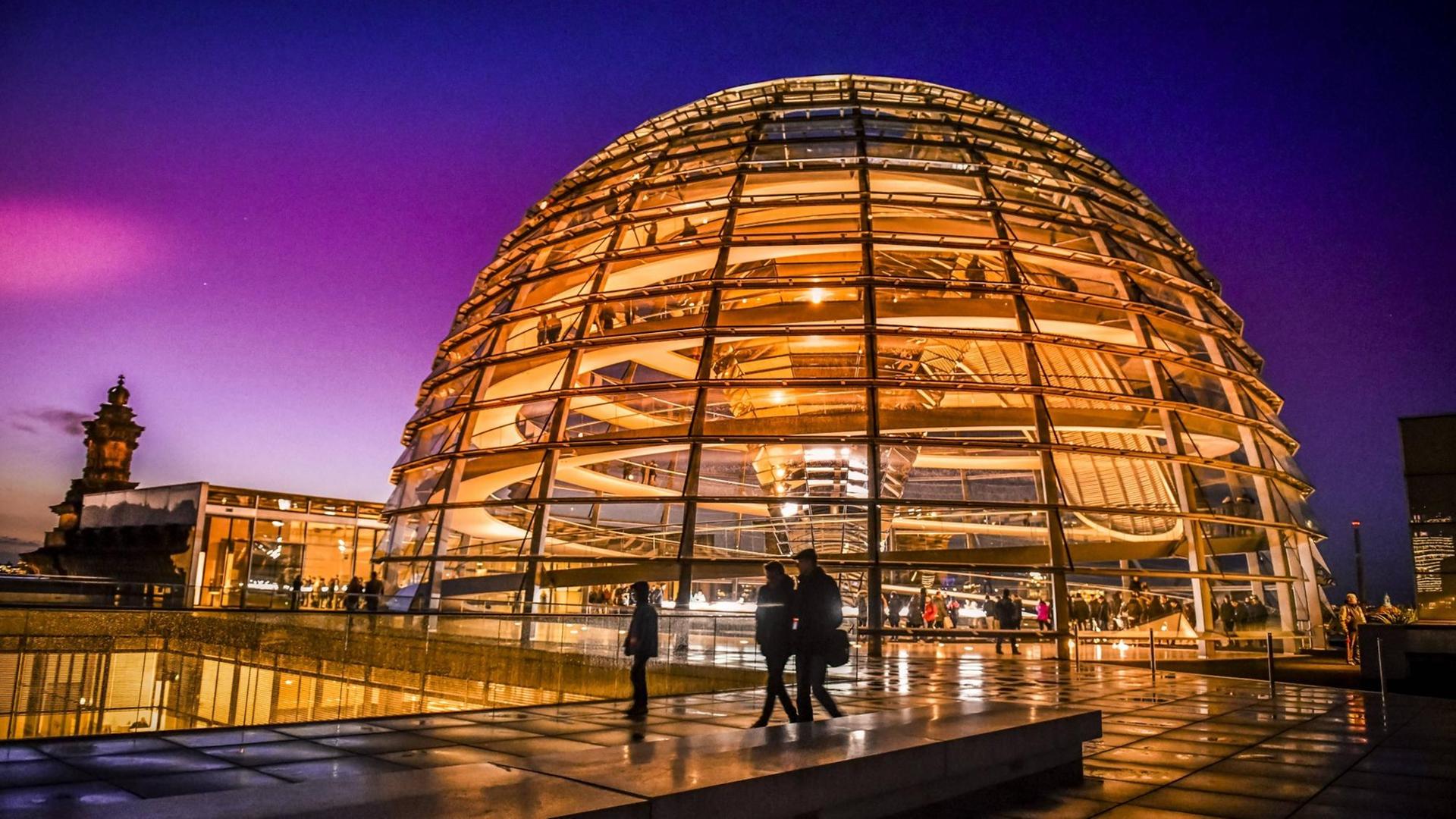 Die orange illuminierte Reichstagskuppel in einer Nachtansicht. Die orange illuminierte Reichstagskuppel in einer Nachtansicht.