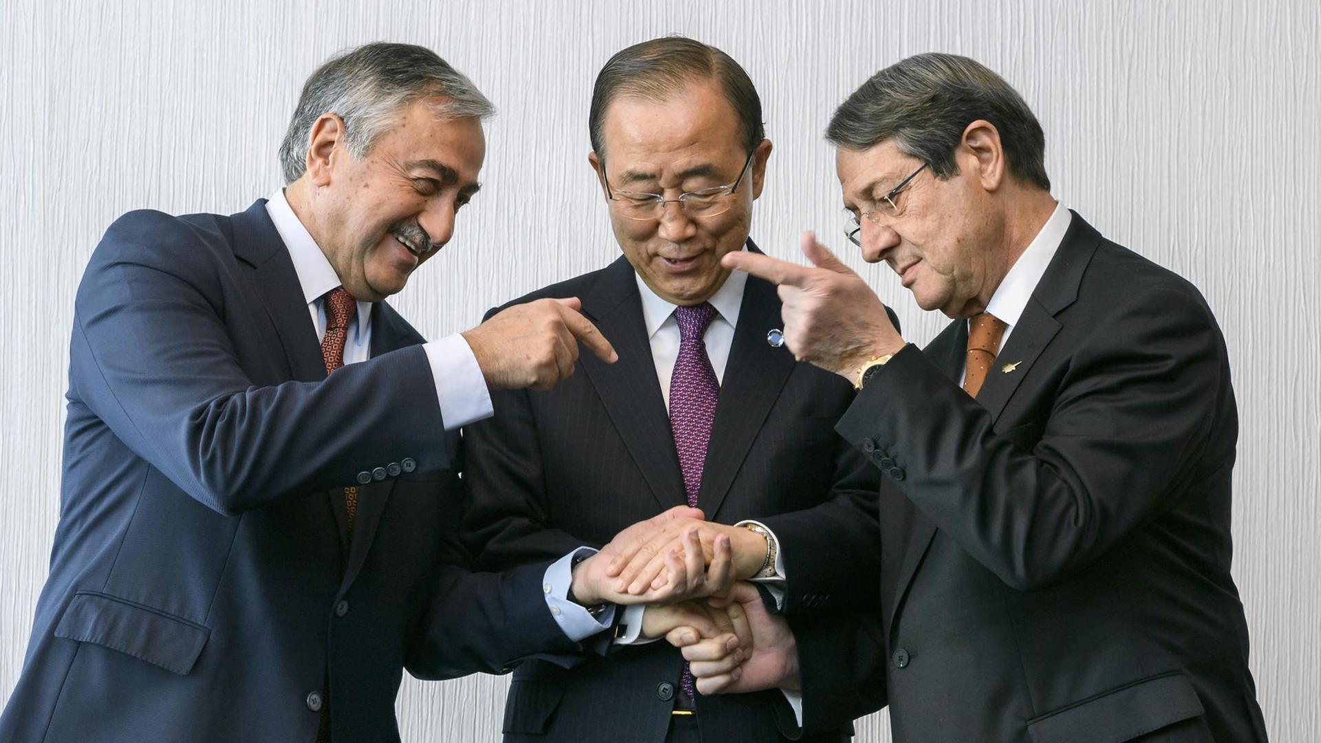 UN-Generalsekretär Ban Ki-Moon (Mitte) bereitet den Handschlag mit dem türkisch zyprischen Präsidenten Mustafa Akinci (links) und dem griechisch-zypriotischen Präsidenten Nicos Anastasiades (rechts) am 07. November 2016 in Mont Pelerin in der Schweiz vor. UN-Generalsekretär Ban Ki-Moon (Mitte) bereitet den Handschlag mit dem türkisch zyprischen Präsidenten Mustafa Akinci (links) und dem griechisch-zypriotischen Präsidenten Nicos Anastasiades (rechts) am 07. November 2016 in Mont Pelerin in der Schweiz vor.