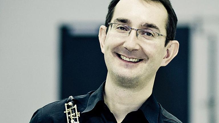 Der Oboist hält lachend sein Instrument in der Hand. Der Oboist hält lachend sein Instrument in der Hand.