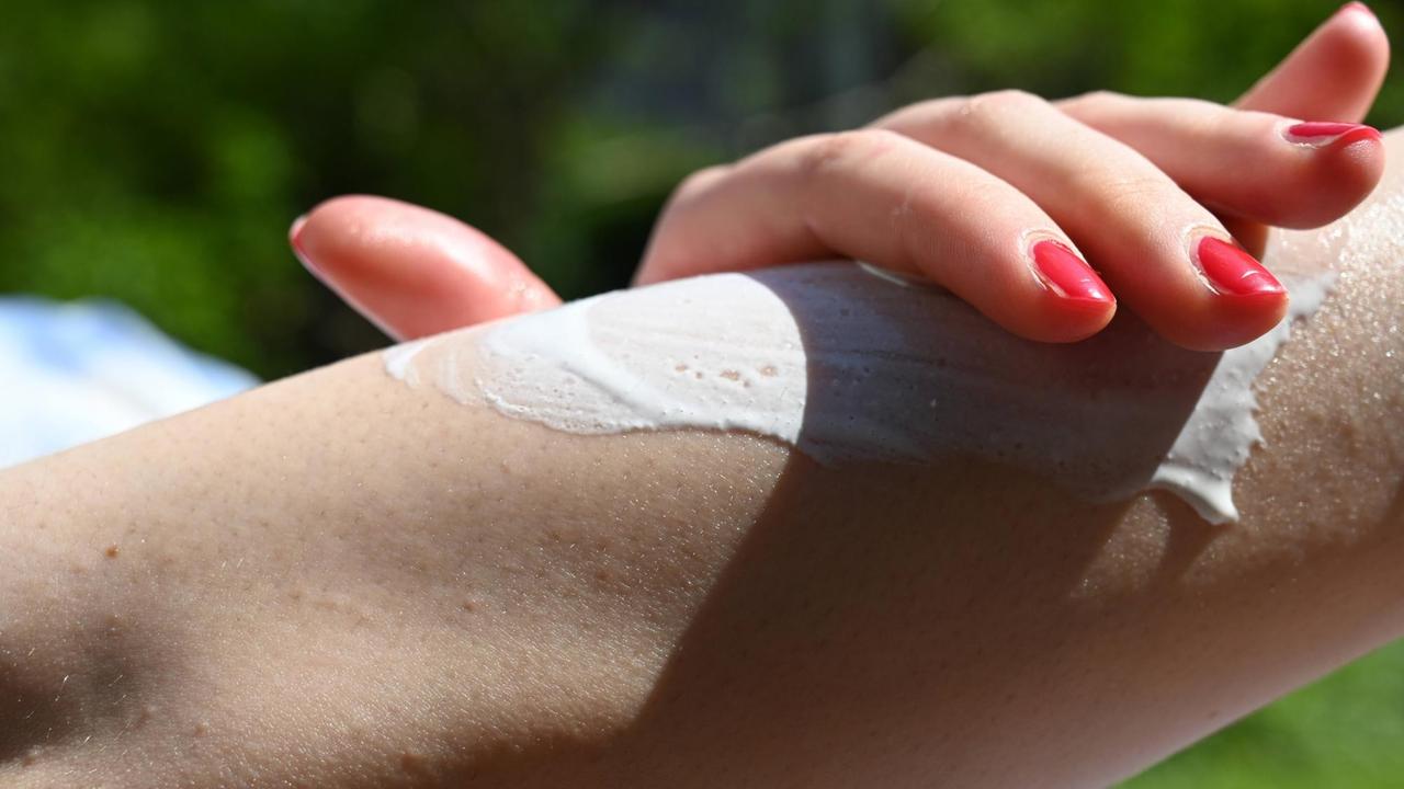 Junge Frau trägt Sonnensucht auf. Junge Frau trägt Sonnensucht auf.