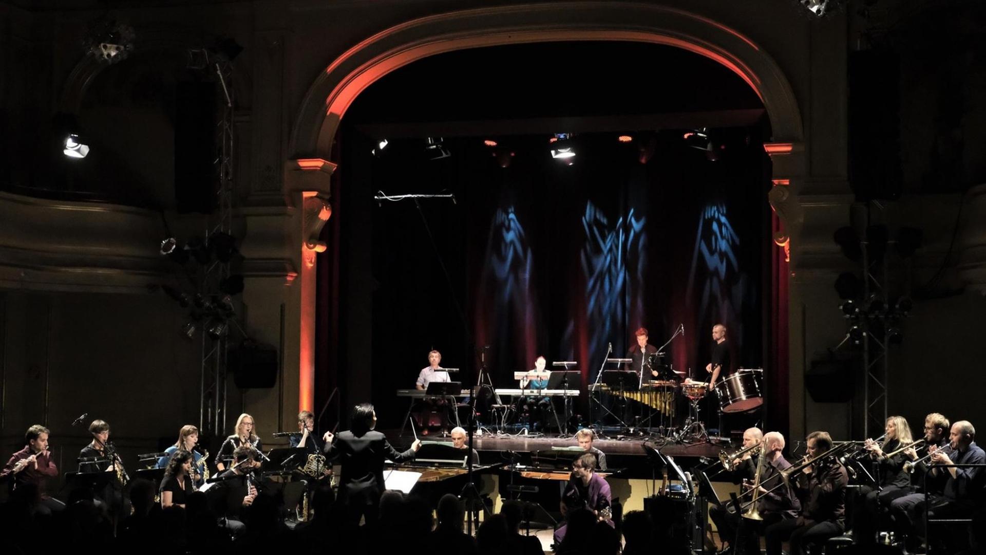 In einer Veranstaltung im Berliner Heimathafen spielt ein Ensemble mit großem Bläsersatz In einer Veranstaltung im Berliner Heimathafen spielt ein Ensemble mit großem Bläsersatz