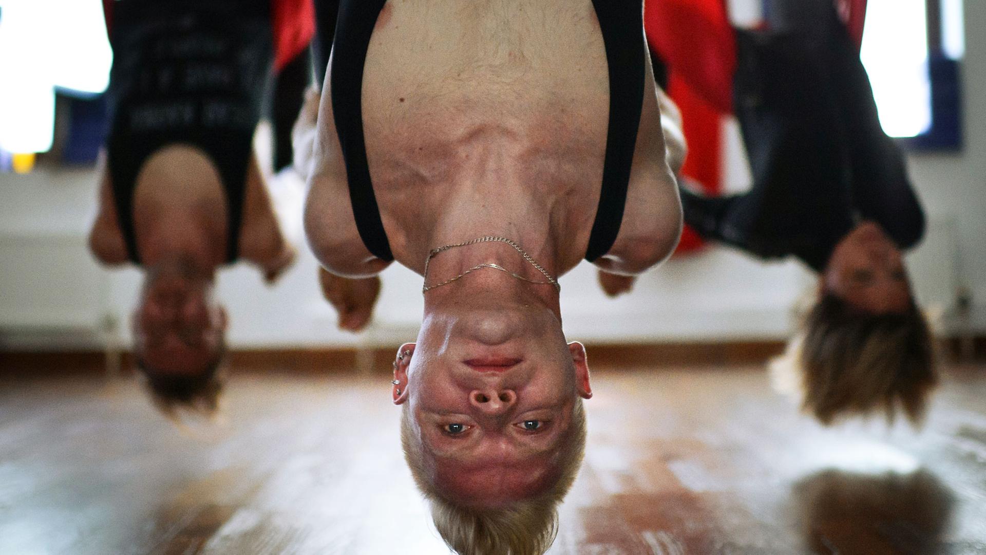 Kopfüber: Beim sogenannten Antigravity-Yoga hängen die Teilnehmer in einer Schlaufe. Kopfüber: Beim sogenannten Antigravity-Yoga hängen die Teilnehmer in einer Schlaufe.