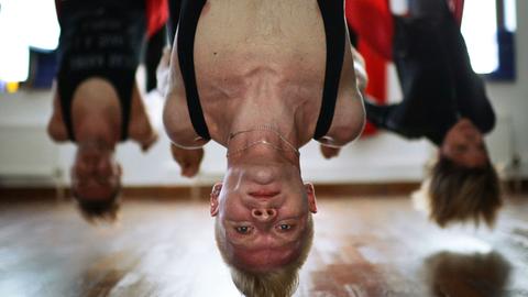 Kopfüber: Beim sogenannten Antigravity-Yoga hängen die Teilnehmer in einer Schlaufe.