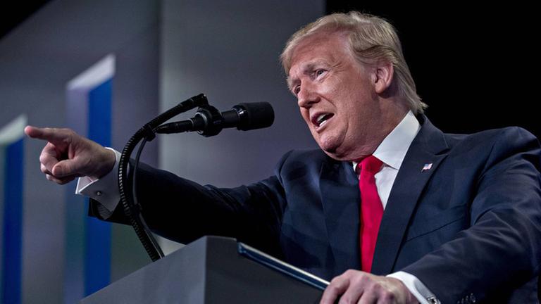 US-Präsident Donald Trump steht während eine Rede an einem Pult und zeigt mit dem Zeigefinger geradeaus. US-Präsident Donald Trump steht während eine Rede an einem Pult und zeigt mit dem Zeigefinger geradeaus.