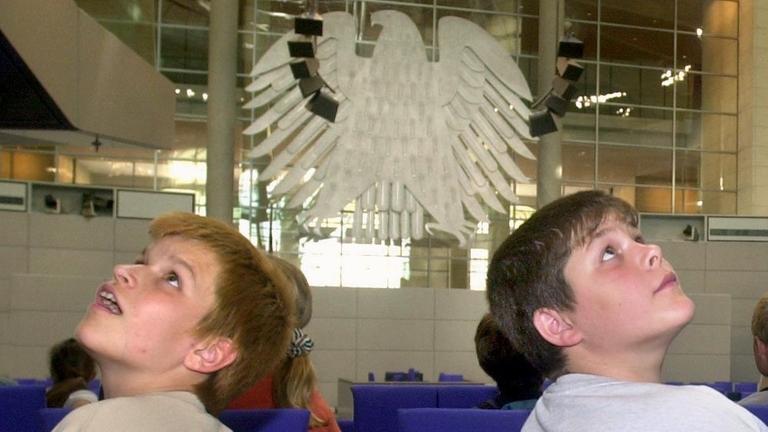 Mit großen Augen betrachten zwei Schüler die Kuppel über dem Plenarsaal des Berliner Reichstags