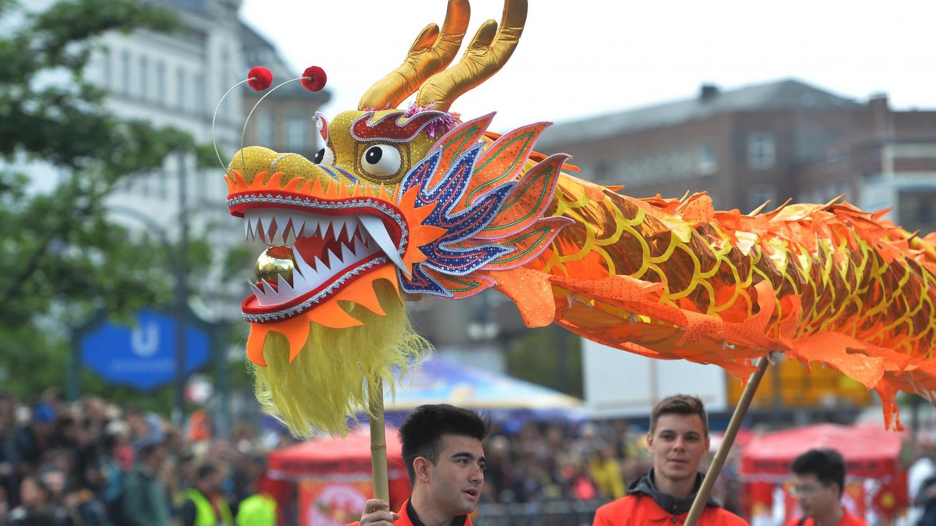 Mit einem asiatischen Papierdrachen zieht eine Gruppe am 15.05.2016 in Berlin am Straßenumzug zum 21. Karneval der Kulturen teil. Mit einem asiatischen Papierdrachen zieht eine Gruppe am 15.05.2016 in Berlin am Straßenumzug zum 21. Karneval der Kulturen teil.