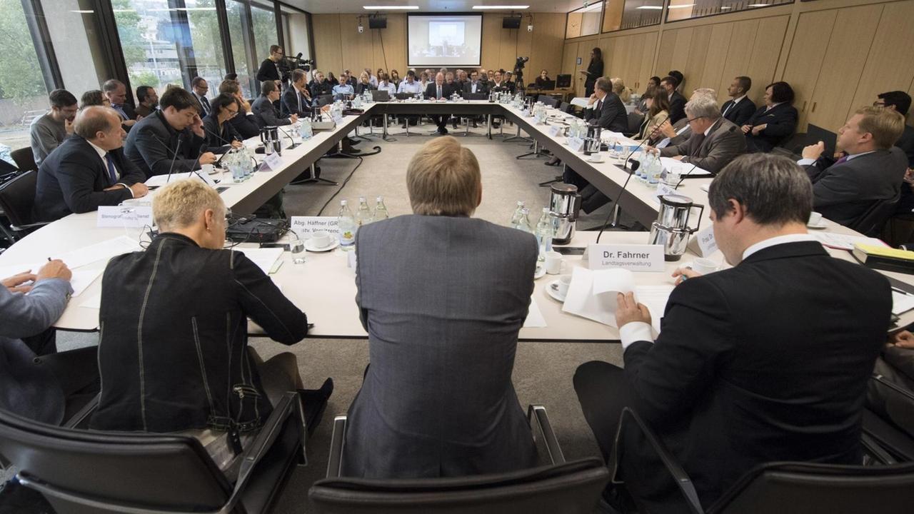 Das Bild zeigt den runden Tisch mit den Ausschussmitgliedern in einem Konferenzraum. Das Bild zeigt den runden Tisch mit den Ausschussmitgliedern in einem Konferenzraum.