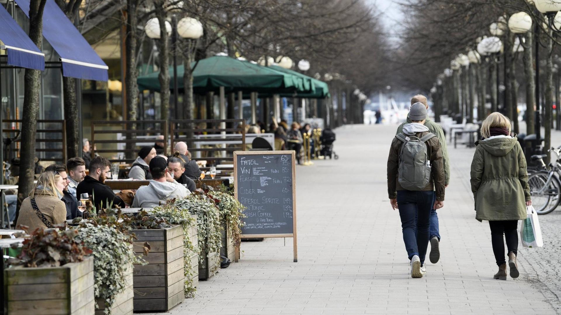 Promenade in Stockholm, über die an einem Nachmittag viele Menschen laufen, auch die Straßencafes sind gut gefüllt. Promenade in Stockholm, über die an einem Nachmittag viele Menschen laufen, auch die Straßencafes sind gut gefüllt.