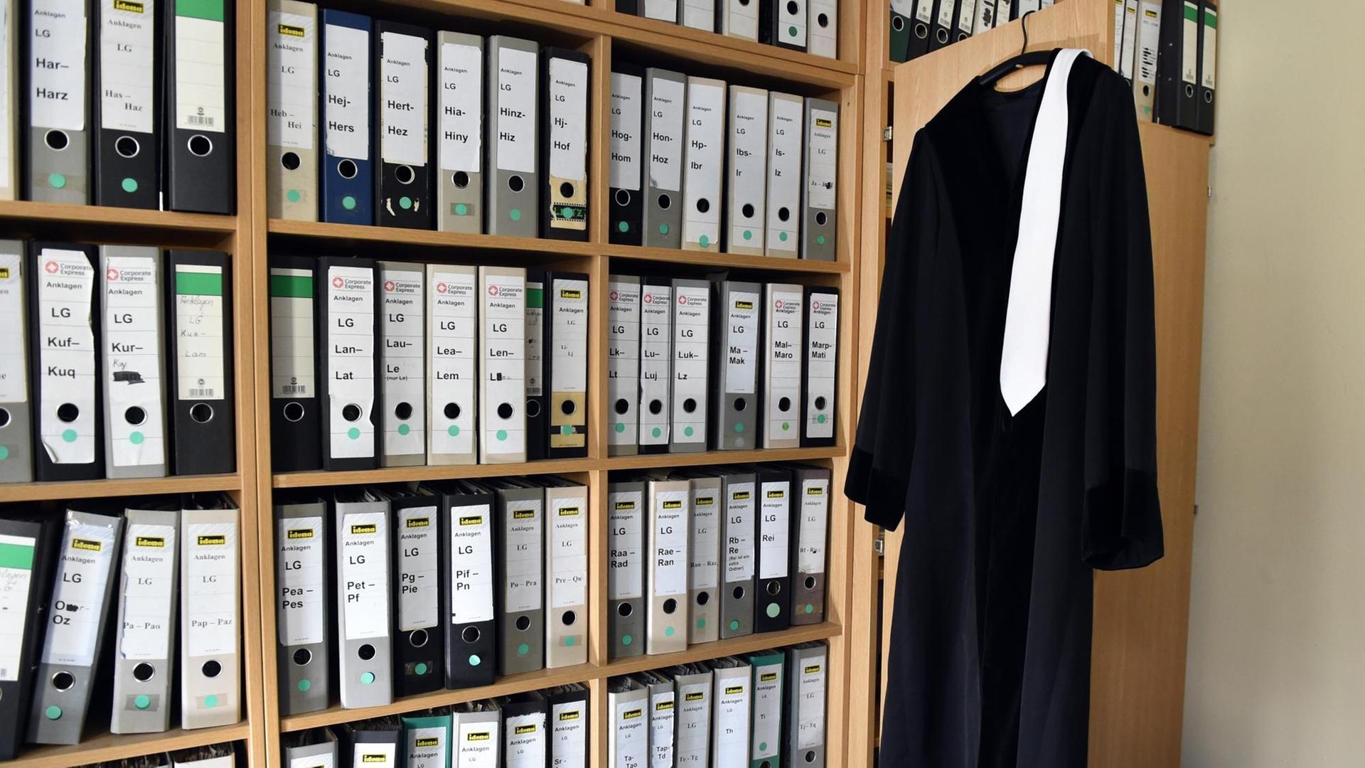 Eine Richterrobe hängt am 06.08.2014 in Berlin in einem Raum eines Gerichts auf einem Bügel an einem Schrank neben vielen Aktenordnern. Eine Richterrobe hängt am 06.08.2014 in Berlin in einem Raum eines Gerichts auf einem Bügel an einem Schrank neben vielen Aktenordnern.