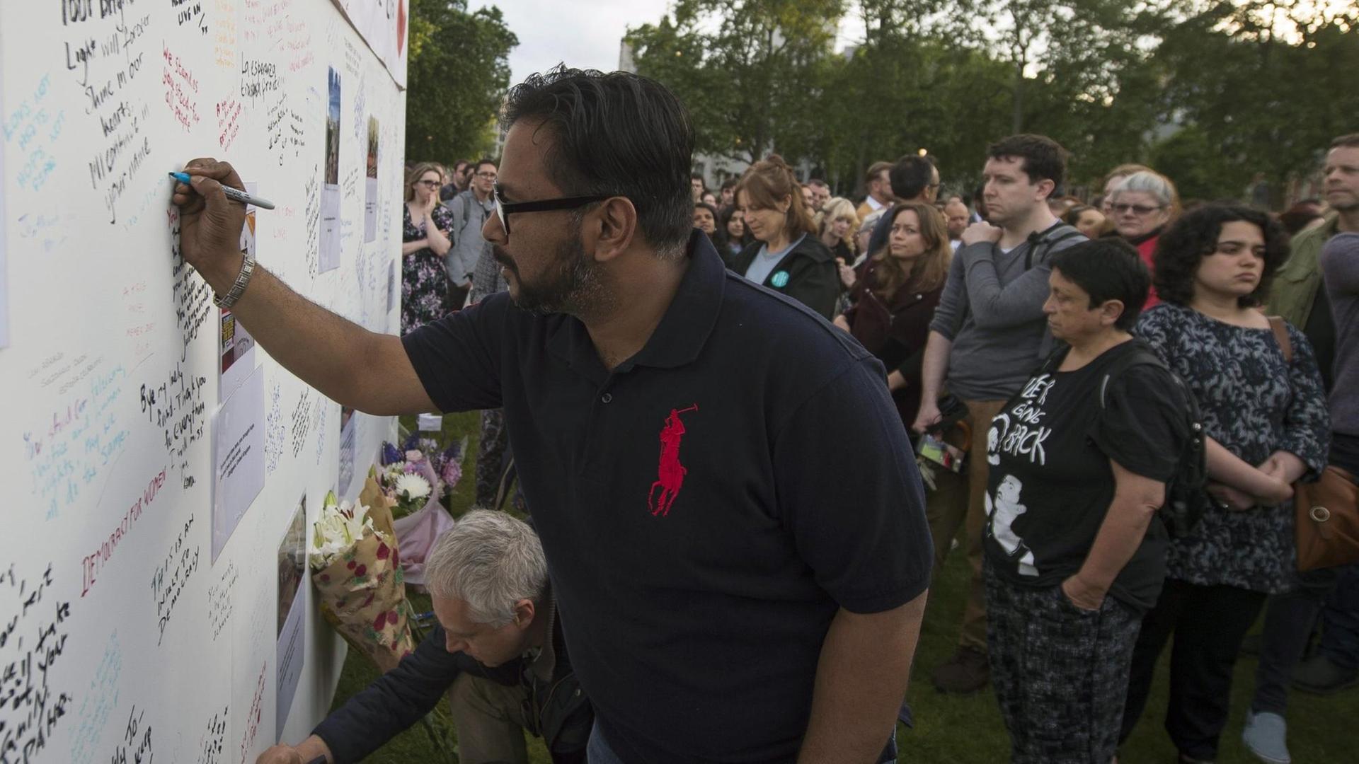 Trauernde schreiben bei einer Andacht in London Botschaften an eine Wand, die an die nach einem Attentat verstorbene britische Labour-Abgeordnete Jo Cox erinnern soll. Trauernde schreiben bei einer Andacht in London Botschaften an eine Wand, die an die nach einem Attentat verstorbene britische Labour-Abgeordnete Jo Cox erinnern soll.