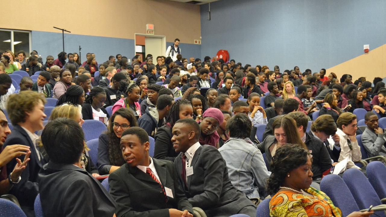 Ein Hörsaal der African Leadership Academy mit zahlreichen Studierende auf blauen gepolsterten Sitzen .
