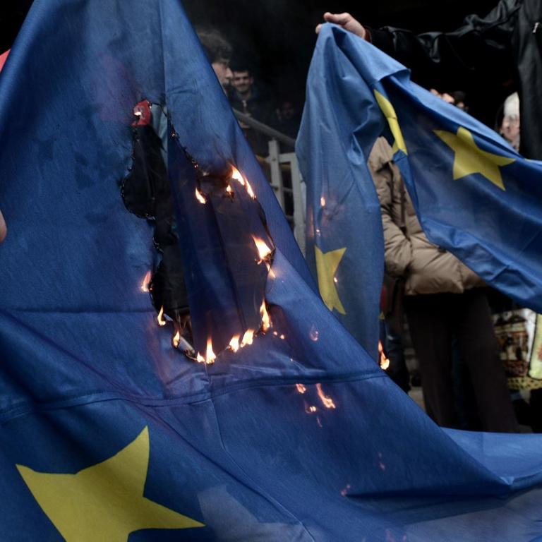 Demonstranten verbrennen eine EU-Flagge, als sie am 10. Januar 2018 vor dem Gerichtsgebäude in Thessaloniki gegen Versteigerungen von Immobilien protestieren.