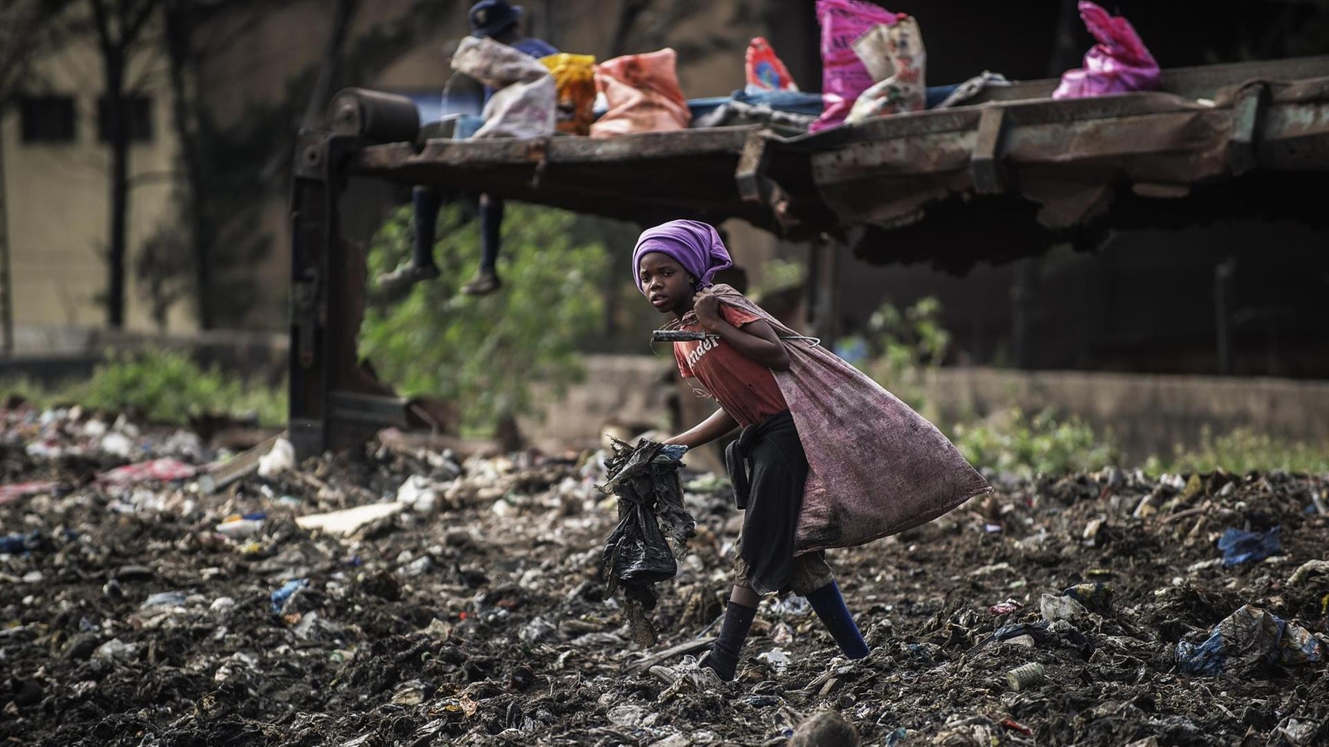 Ein Mädchen läuft in Maputo in Mosambik über eine Müllhalde und sammelt noch verwertbaren Abfall. Ein Mädchen läuft in Maputo in Mosambik über eine Müllhalde und sammelt noch verwertbaren Abfall.