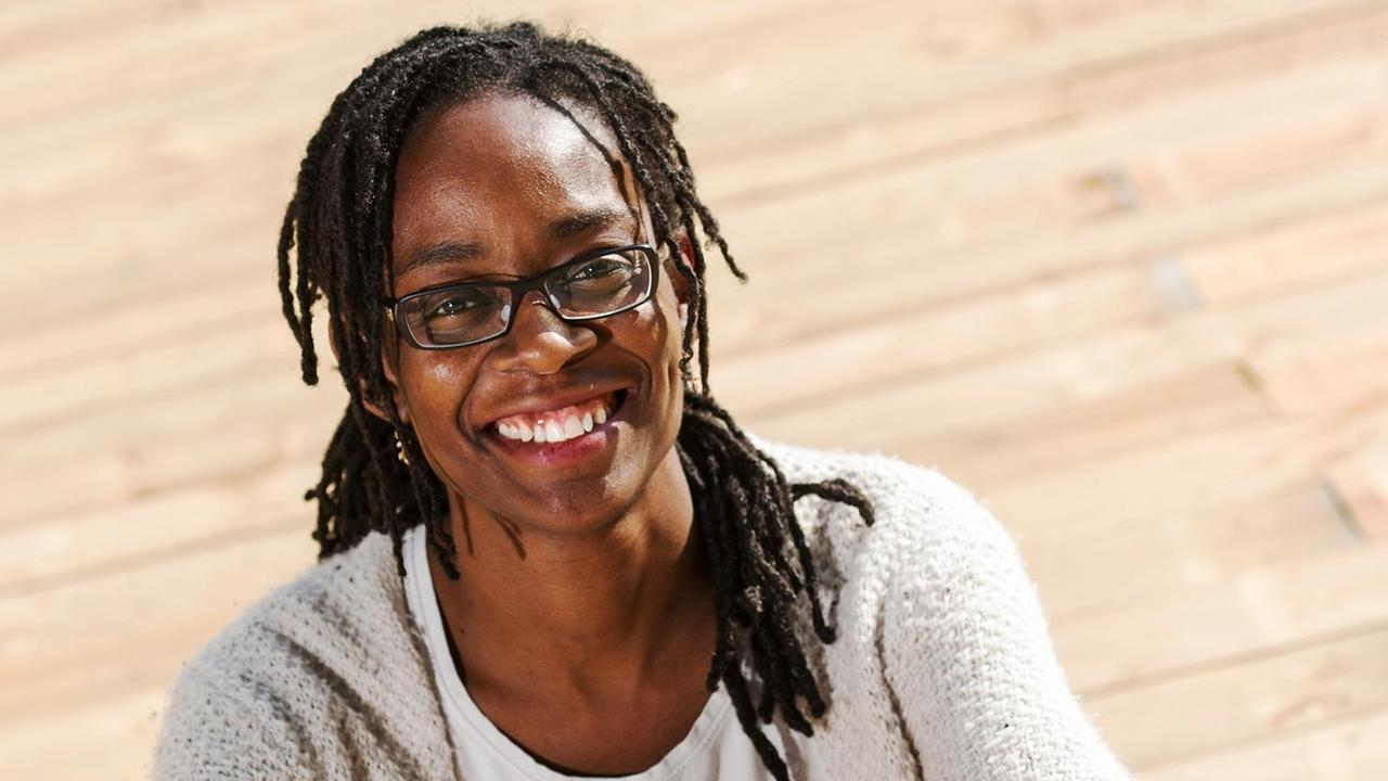Poträtaufnahme der Autorin und Bachman-Preisträgerin Sharon Dodua Otoo vor einem hellen hölzernen Hintergrund. Poträtaufnahme der Autorin und Bachman-Preisträgerin Sharon Dodua Otoo vor einem hellen hölzernen Hintergrund.