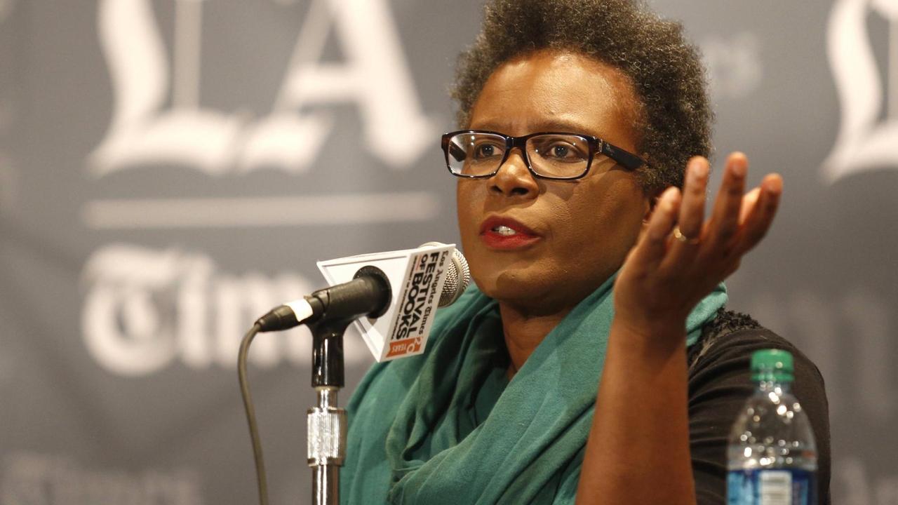 Claudia Rankine spricht auf einem Podium in ein Mikrofon Claudia Rankine spricht auf einem Podium in ein Mikrofon