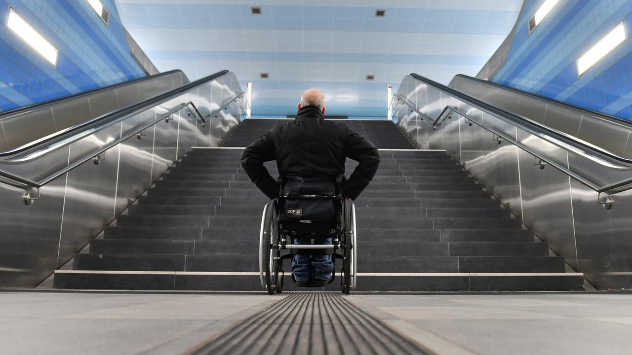 Ein Mann im Rollstuhl steht vor einer Treppe und kommt nicht weiter (Symbolfoto)