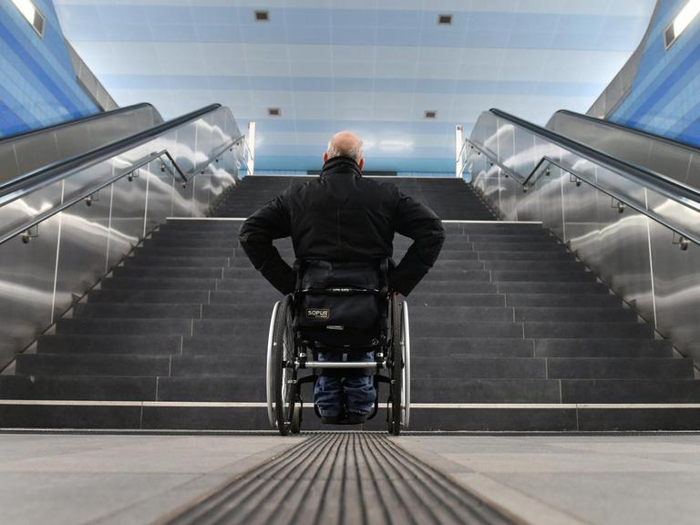 Ein Mann im Rollstuhl steht vor einer Treppe und kommt nicht weiter (Symbolfoto)
