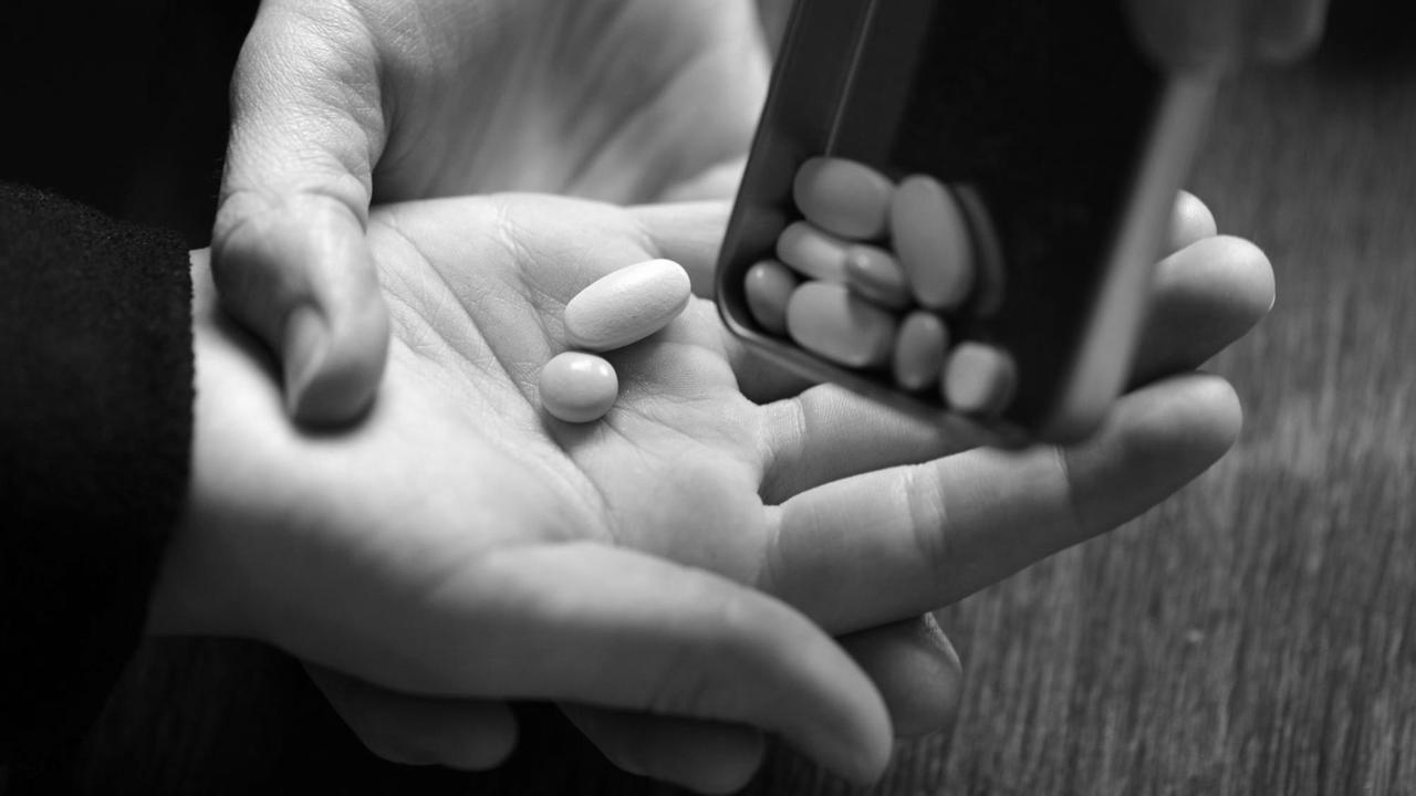 Illustration - Ein Mädchen bekommt verschiedene Tabletten in die Hand geschüttet, aufgenommen am 19.02.2014 in Berlin. Foto: Jens Kalaene/dpa | Verwendung weltweit