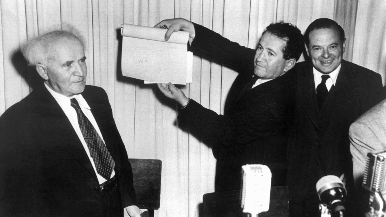 Nach der Unterzeichnung der Proklamationsurkunde am 14. Mai 1948 im Stadtmuseum von Tel Aviv hält eine nicht identifizierte Person das Schriftstück mit den Unterschriften in die Höhe, links David Ben Gurion, der erste Ministerpräsident Israels. Nach der Unterzeichnung der Proklamationsurkunde am 14. Mai 1948 im Stadtmuseum von Tel Aviv hält eine nicht identifizierte Person das Schriftstück mit den Unterschriften in die Höhe, links David Ben Gurion, der erste Ministerpräsident Israels.