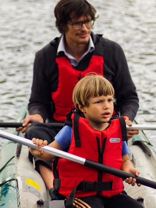 Ein Mann macht mit einem Jungen eine Bootstour.