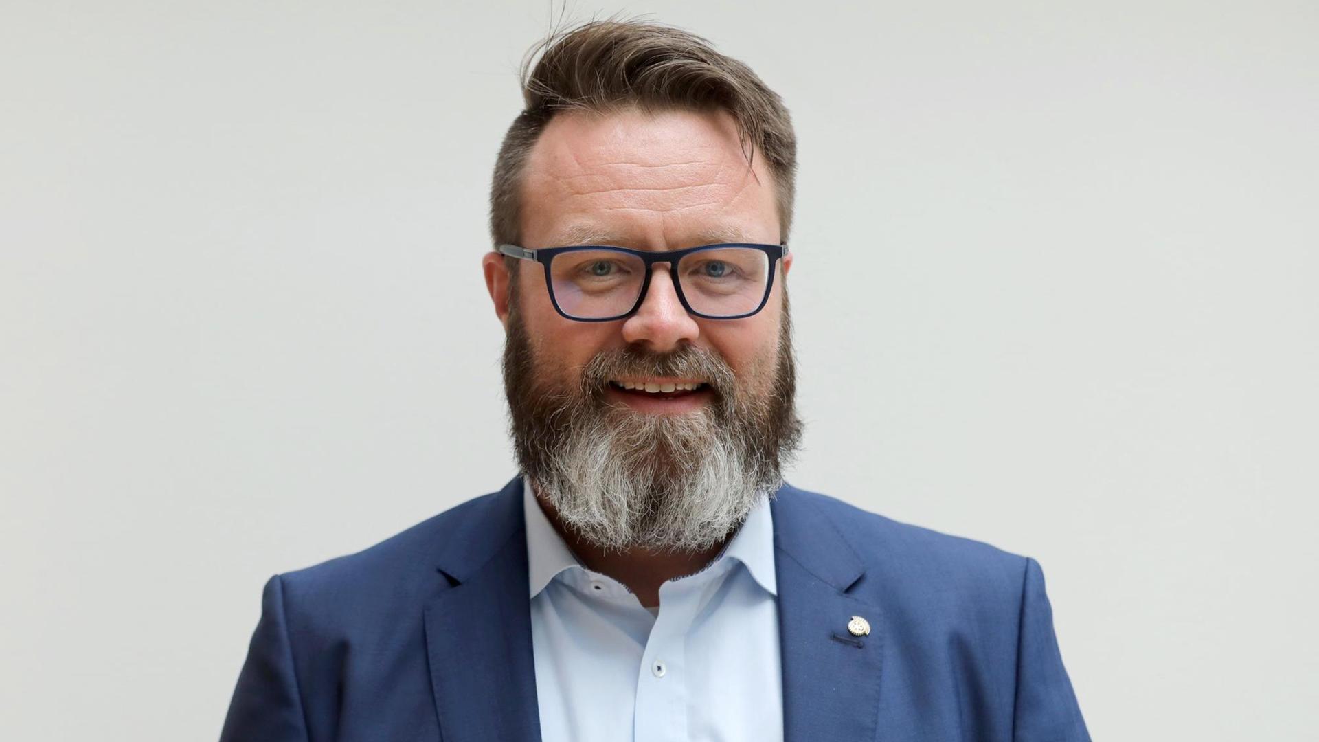 Der Rostocker Oberbürgermeisterkandidat Claus Ruhe Madsen schaut in die Kamera. Er hat einen Seitenscheitel und einen Vollbart. Der Rostocker Oberbürgermeisterkandidat Claus Ruhe Madsen schaut in die Kamera. Er hat einen Seitenscheitel und einen Vollbart.