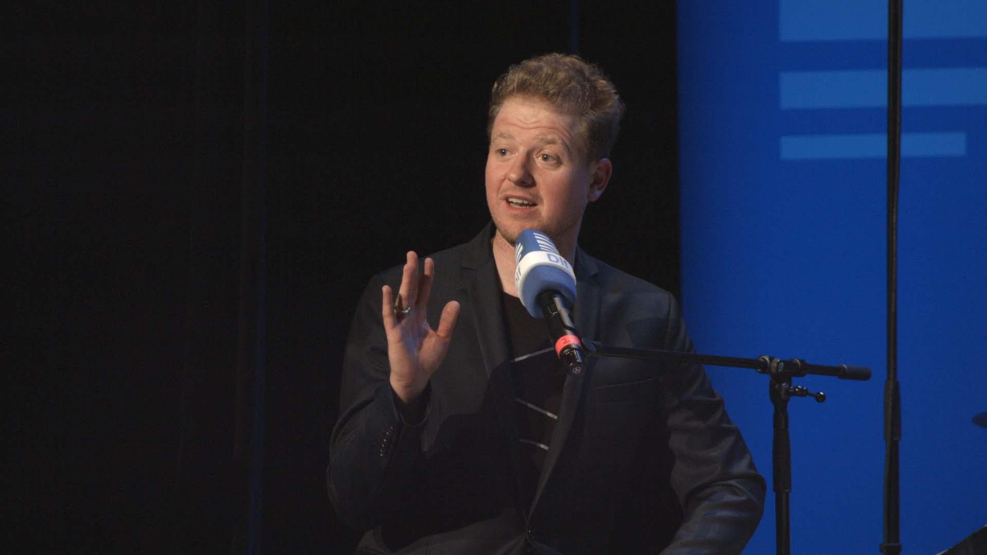 Musikkabarettist Martin Zingsheim sitzend vor einem Mikrofon Musikkabarettist Martin Zingsheim sitzend vor einem Mikrofon
