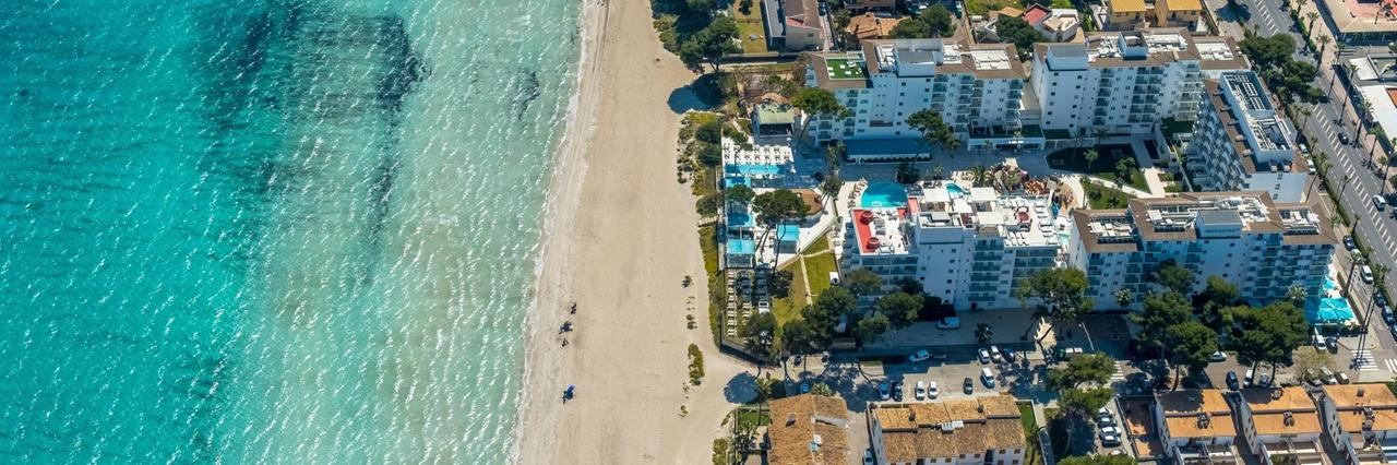 Luftaufnahme vom Strand von Alcúdia mit angrenzenden Hotelanlagen. Luftaufnahme vom Strand von Alcúdia mit angrenzenden Hotelanlagen.