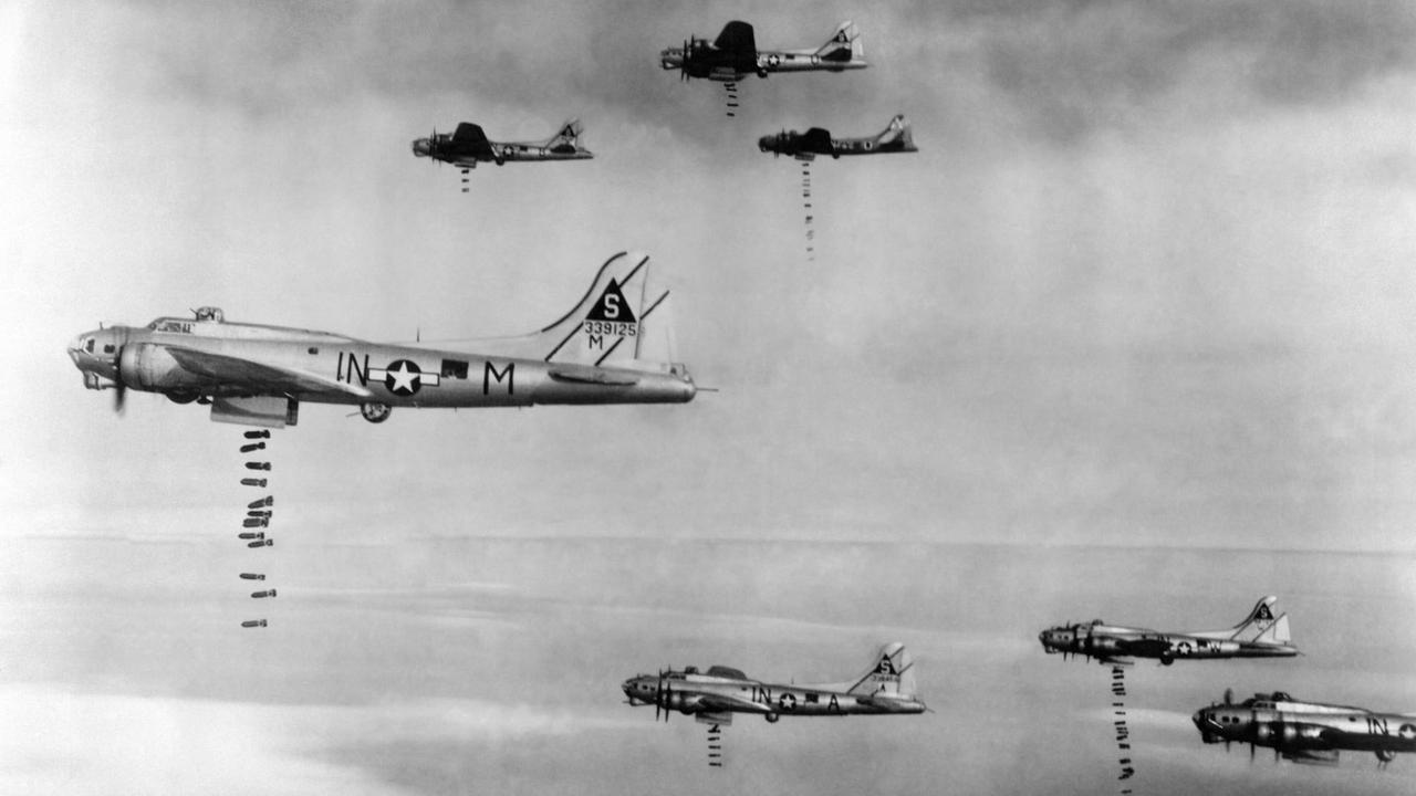 Das Foto zeigt amerikanische Bomber im 2. Weltkrieg am Himmel. Aus den Flugzeugen fallen unten Bomben heraus. Das Foto zeigt amerikanische Bomber im 2. Weltkrieg am Himmel. Aus den Flugzeugen fallen unten Bomben heraus.