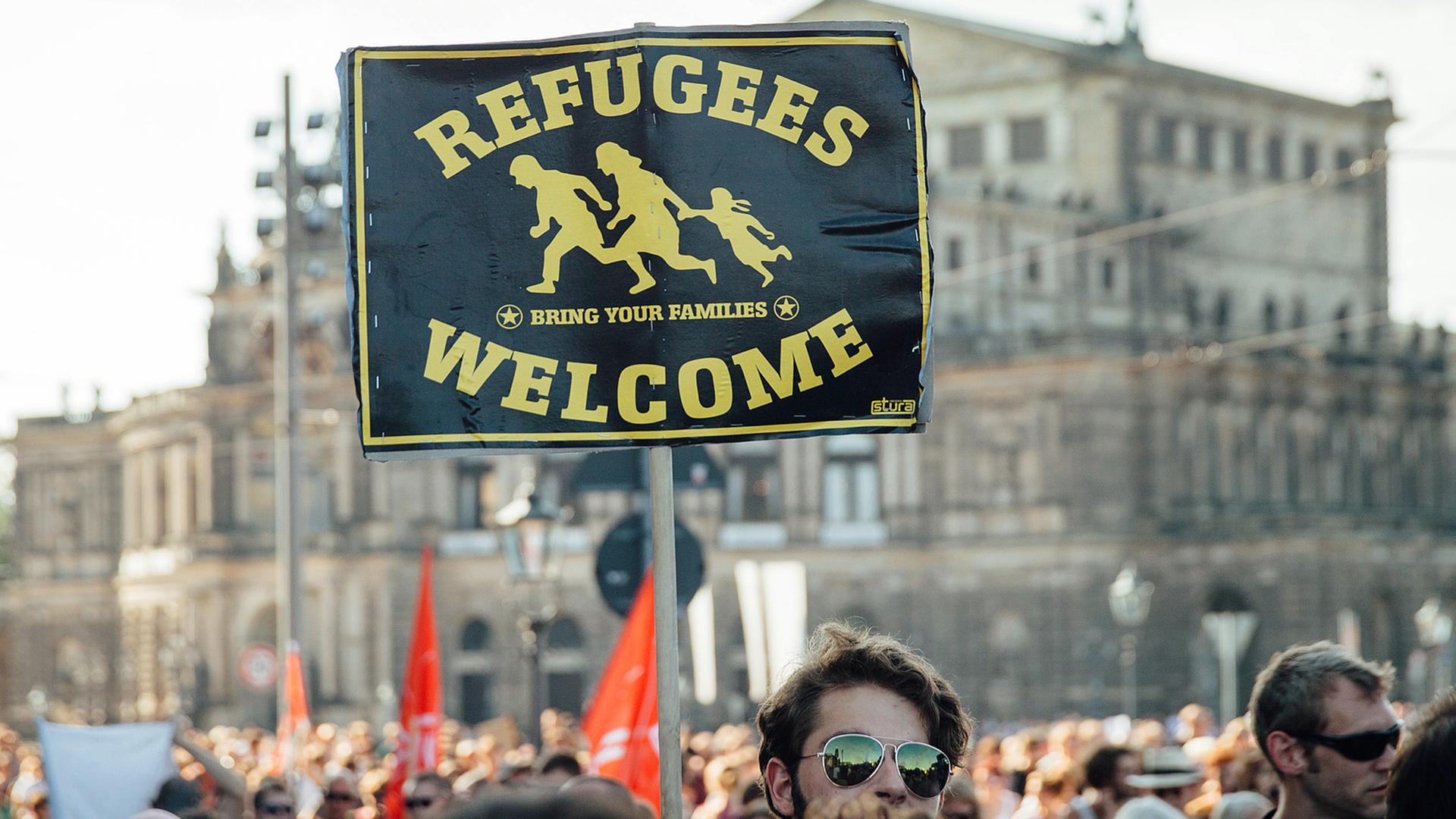 Teilnehmer einer Demonstration stehen Ende August 2015 mit einem Schild mit der Aufschrift "Refugees welcome" in der Dresdner Innenstadt. Teilnehmer einer Demonstration stehen Ende August 2015 mit einem Schild mit der Aufschrift "Refugees welcome" in der Dresdner Innenstadt.