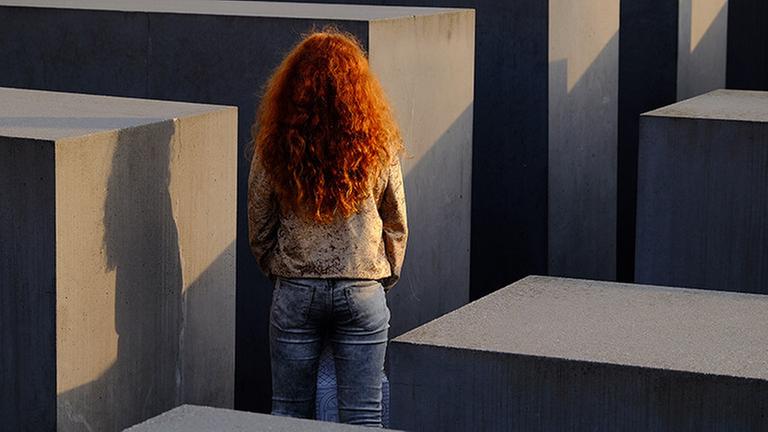 October 23, 2019, Berlin, Berlin, Germany: A red-haired girl can be seen at the Memorial to the Murdered Jews of Europe German: Denkmal für die ermordeten Juden Europas, also known as the Holocaust Memorial German: Holocaust-Mahnmal during Sunset in Central Berlin. Designed by architect Peter Eisenman, the monument is composed of 2711 rectangular concrete blocks, laid out in a grid formation. Berlin Germany PUBLICATIONxINxGERxSUIxAUTxONLY - ZUMAs172 20191023zaps172022 Copyright: xJanxScheunertx