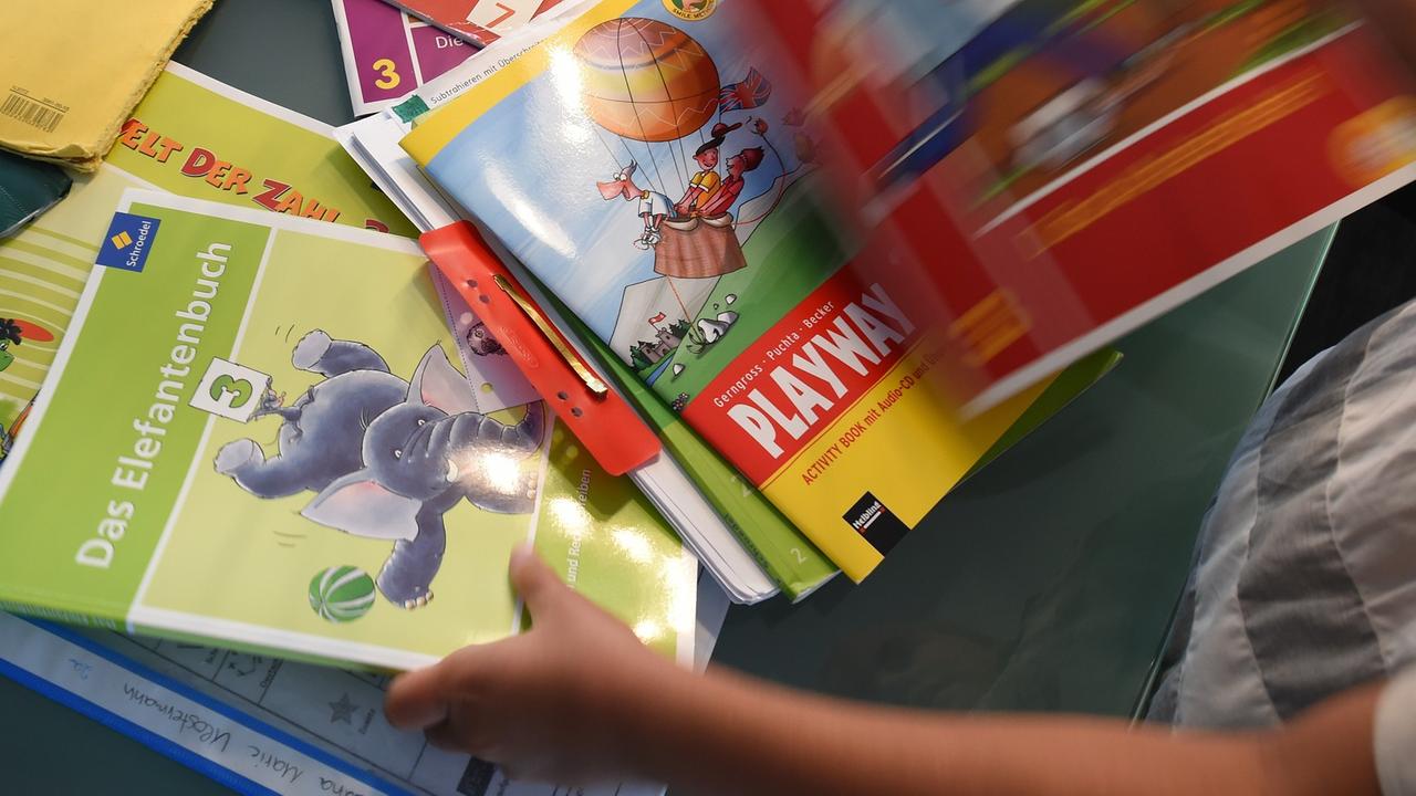 Eine Grundschülerin sortiert ihre Schulbücher Eine Grundschülerin sortiert ihre Schulbücher