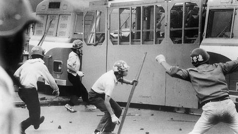 Japanische Studenten werfen am 1.8.1968 Steine auf Fahrzeuge der Polizei am Eingang des Flughafens in Tokio