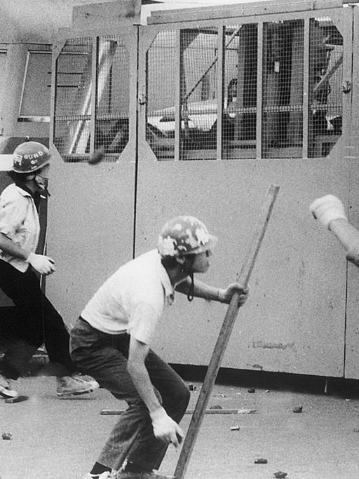 Japanische Studenten werfen am 1.8.1968 Steine auf Fahrzeuge der Polizei am Eingang des Flughafens in Tokio