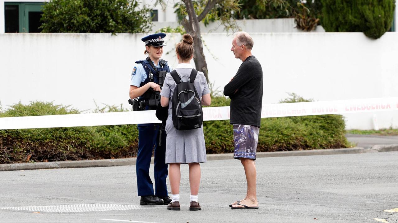 Eine Polizistin spricht in der Nähe einer angegriffenen Moschee in Christchurch mit zwei Anwohnern. Das Gelände ist mit einem Band abgesperrt. Eine Polizistin spricht in der Nähe einer angegriffenen Moschee in Christchurch mit zwei Anwohnern. Das Gelände ist mit einem Band abgesperrt.