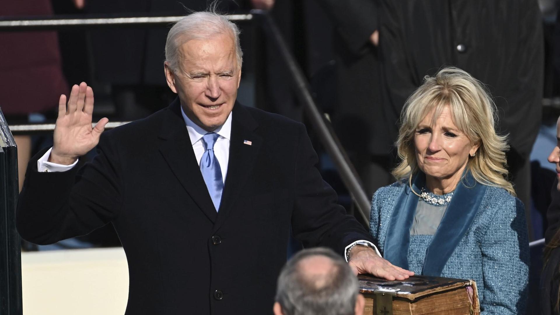 Joe Biden wird als US-Präsident vereidigt und schwört auf die Bibel, rechts von ihm steht seine Ehefrau. Joe Biden wird als US-Präsident vereidigt und schwört auf die Bibel, rechts von ihm steht seine Ehefrau.