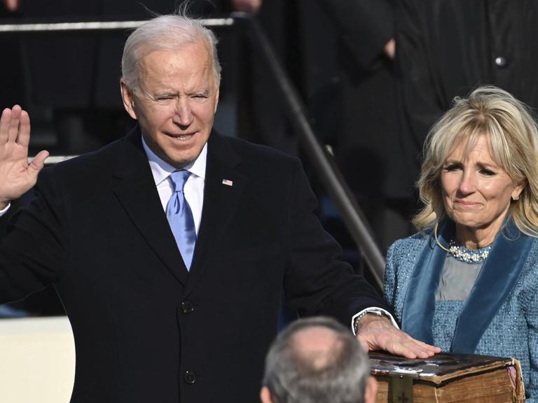 Joe Biden wird als US-Präsident vereidigt und schwört auf die Bibel, rechts von ihm steht seine Ehefrau.